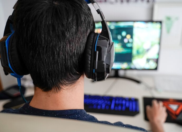 Hombre con auriculares sentado delante de una computadora